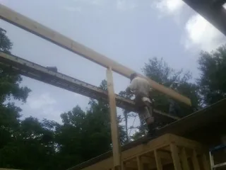 Carpenter setting a ridge beam over a new addition frame — Ice Dam Removal by Roofing Brothers in Bandera