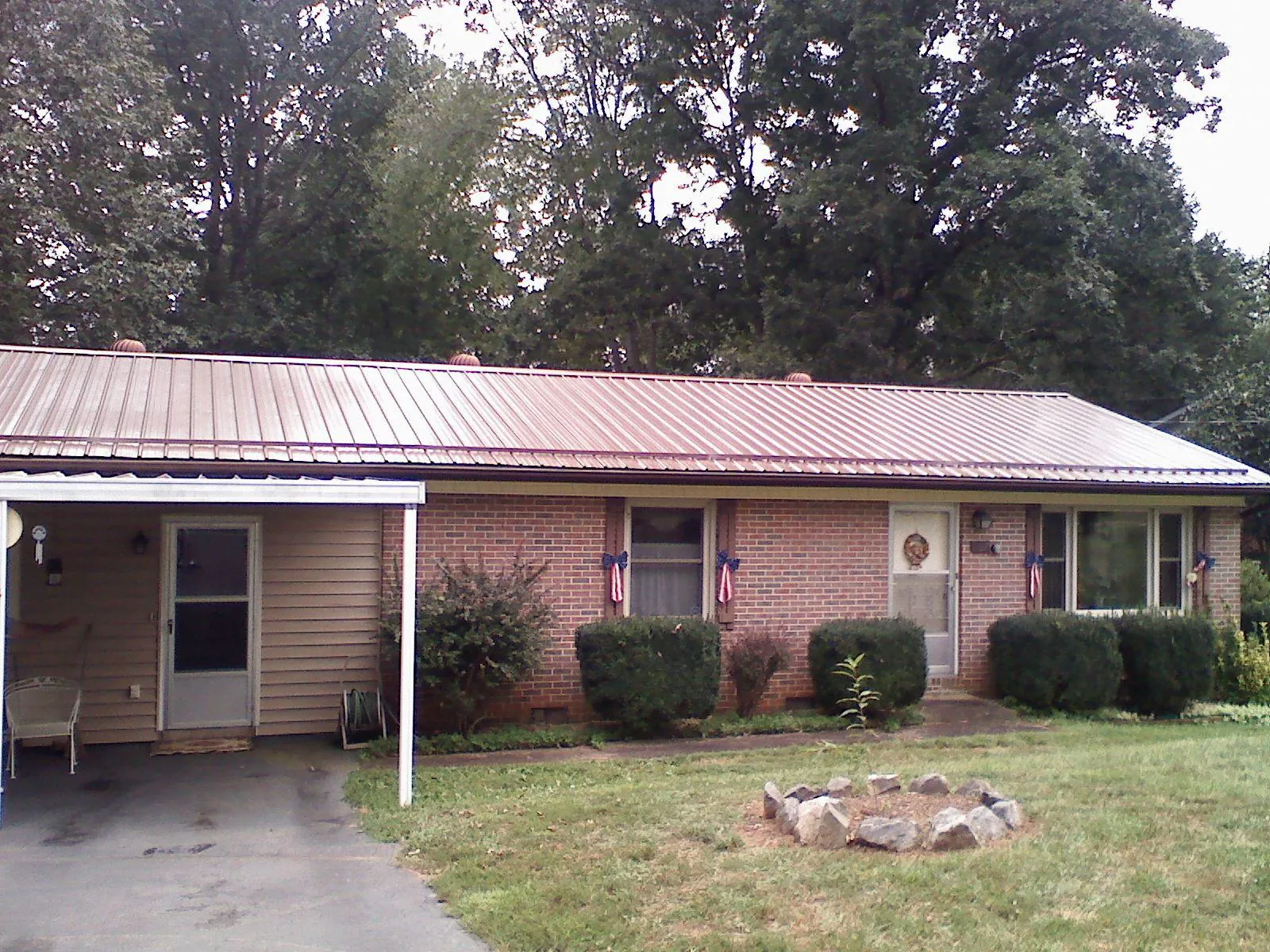 Bronze metal roof and carport on a brick ranch home — Roof Repair work by our crew in Bandera