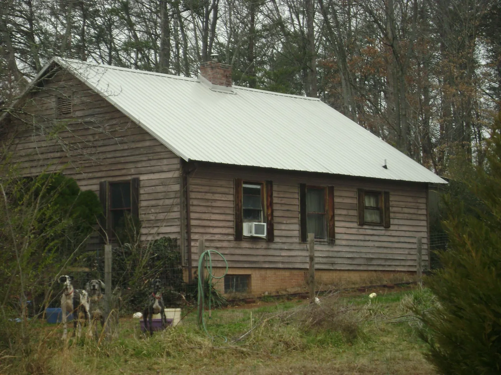 White metal roof on an old wood sided farmhouse, from a Metal Roof Installation job in Bandera
